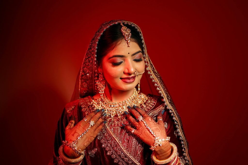 Stunning Indian bride in vibrant traditional bridal wear with intricate jewelry and henna.